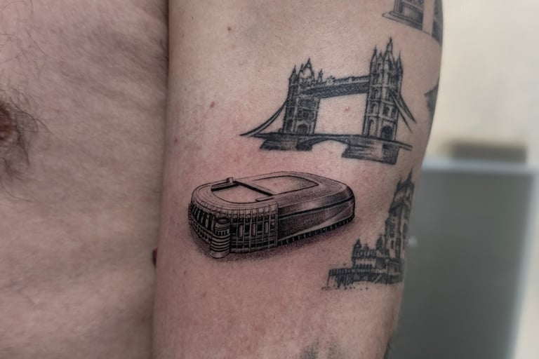 Tatuaje microrealismo en Madrid de Tower Bridge y estadio de fútbol con detalle