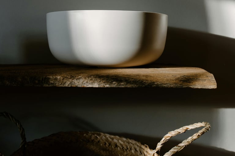 Basin lit by soft side-light in a French Mediterranean bathroom.