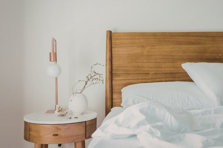 Wood frame and linen bedding in a French Mediterranean bedroom.