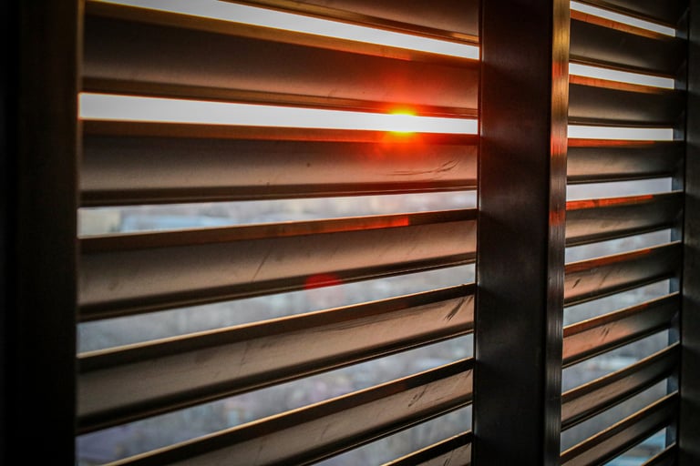 Softened light through a shutter in a French Mediterranean bedroom..