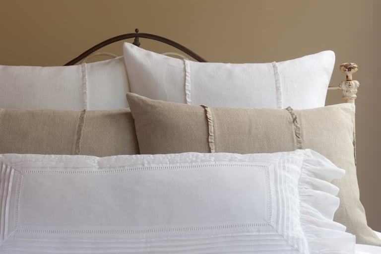 Linen bedding in soft morning light in a French Mediterranean bedroom.