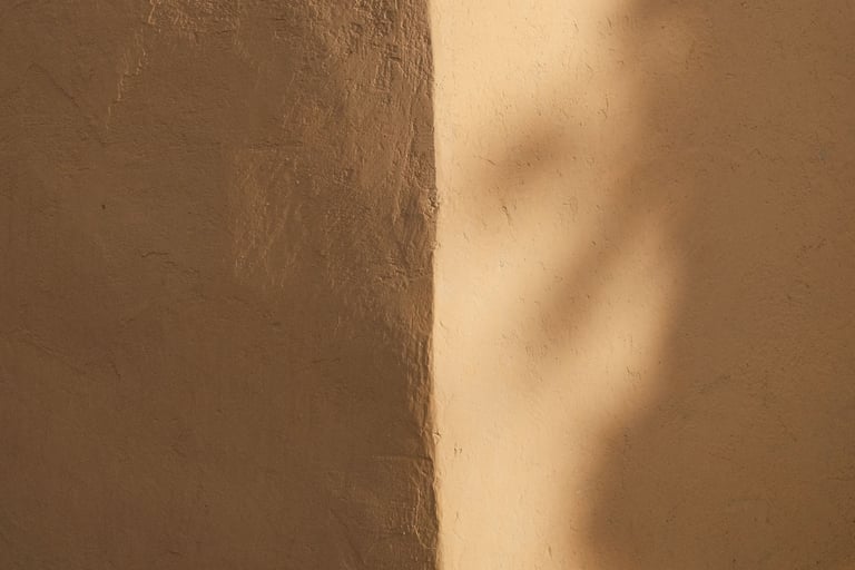 Soft light moving around the corner where two plaster walls meet.