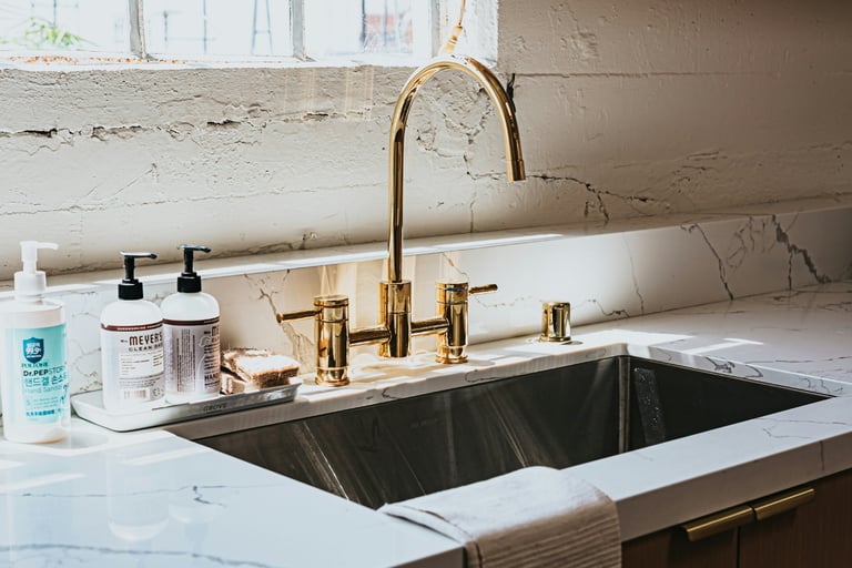 Kitchen sink with an unlacquered brass tap developing a natural patina.