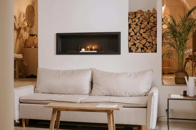 Low linen sofa anchoring a calm French Mediterranean living room, with plaster wall and soft dayligh