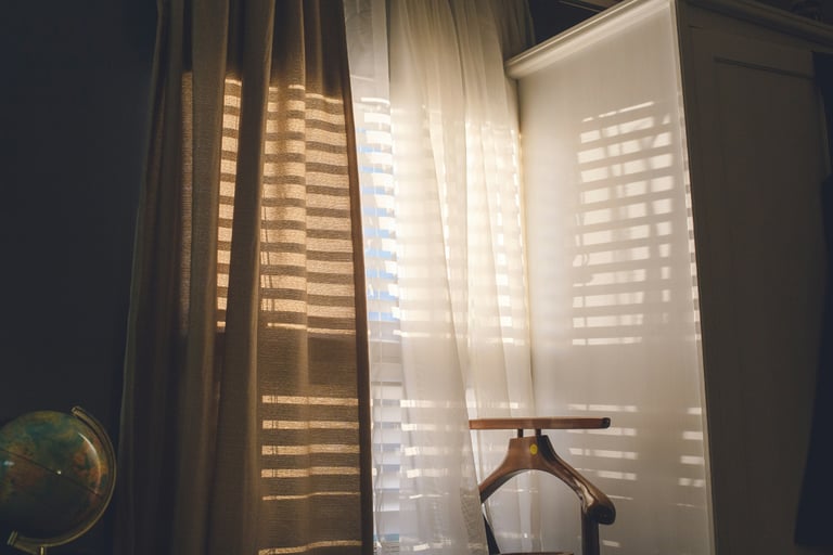 Inside wooden shutters on a new build window, filtering morning light.