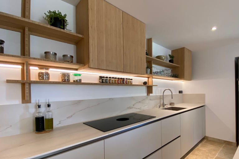 Simple Mediterranean kitchen cabinetry in a warm matte finish with one open shelf.