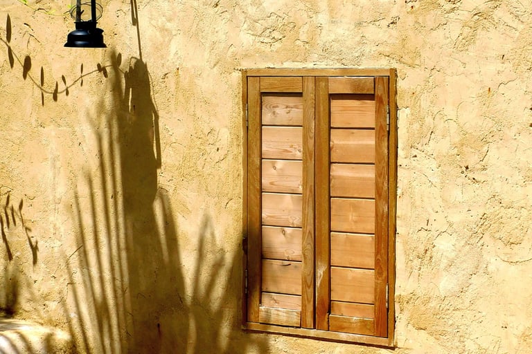 Weathered oak against a lime-washed wall in a French Mediterranean garden.