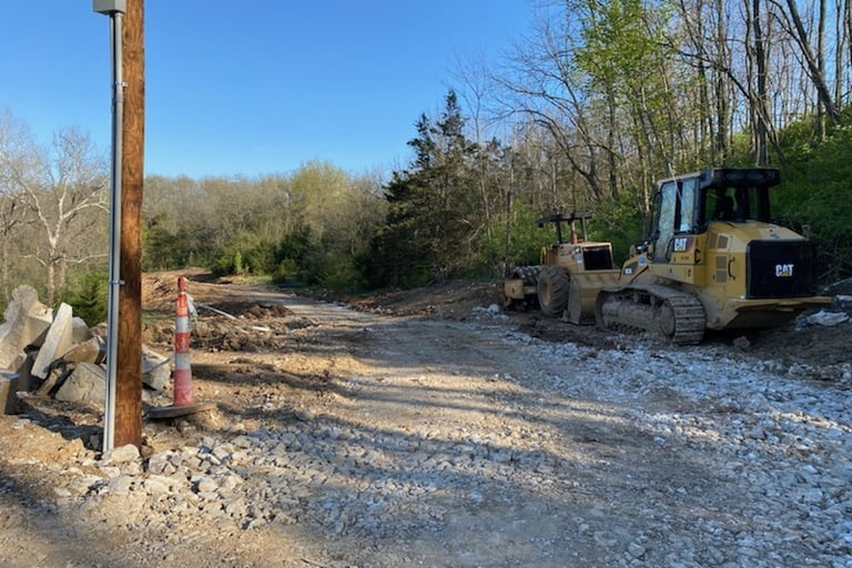 Bulldozer on a trail of mud and rocks, early phases of construction