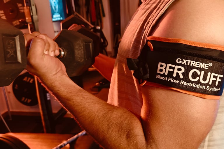 "Client performing upper limb blood flow restriction training with pneumatic cuff on biceps