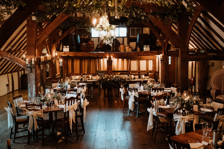 a large room at the Moat in Wrotham with tables and chairs and a chandelier