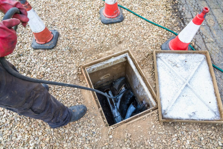 A plumber unblocking a sewage drain using camera inspection.