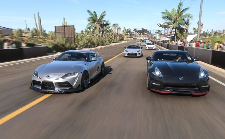 a group of four sports cars driving down a road