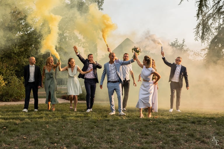 Une photo de groupe avec les mariés et leurs témoins s'amusant avec des fumigènes jaunes
