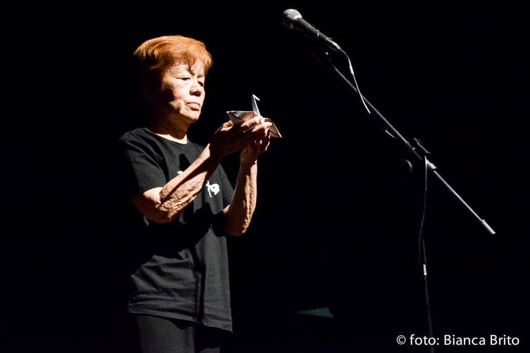 a woman in a black shirt is holding a cell phone