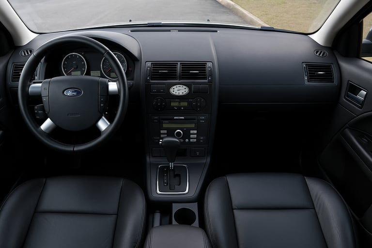 Interior do Ford Mondeo com volante, painel central e bancos em couro preto.