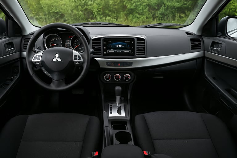 Interior do Mitsubishi Lancer GT, com volante esportivo, painel central e acabamento em preto.