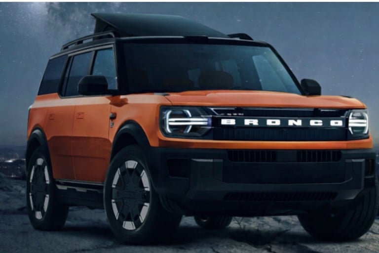 ford bronco suv laranja sem placa frontal em terreno rochoso à noite