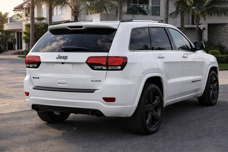 Jeep Grand Cherokee 2015 branco visto pela traseira em ângulo lateral mostrando design de SUV de lux