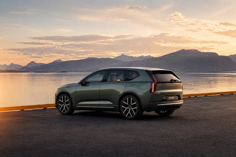 Volvo EX60 elétrico estacionado à beira de lago com montanhas ao fundo e visual sofisticado