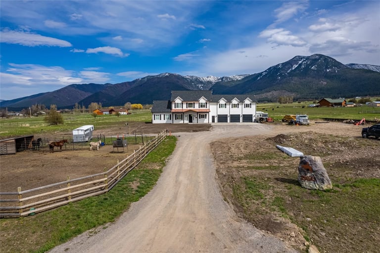 a dirt road with a horse and mountains in the background in Montana