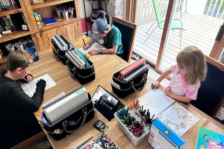 3 kids homeschooling at the table