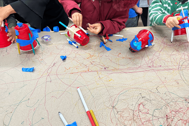 a group of students creating drawing bots at a workshop