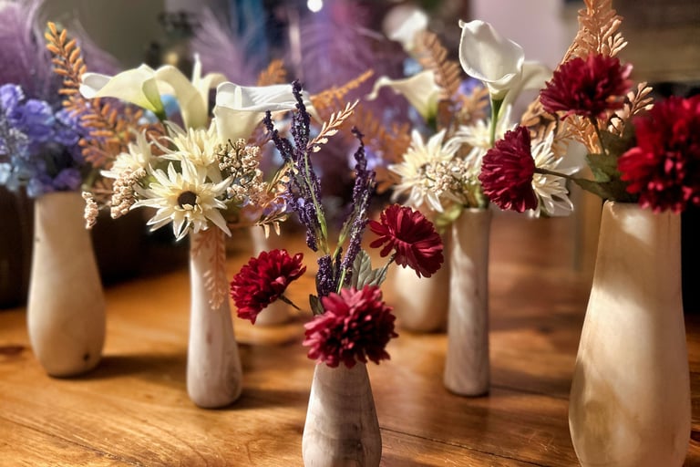 a group of rustic vases with flowers turned from reclaimed tree limbs