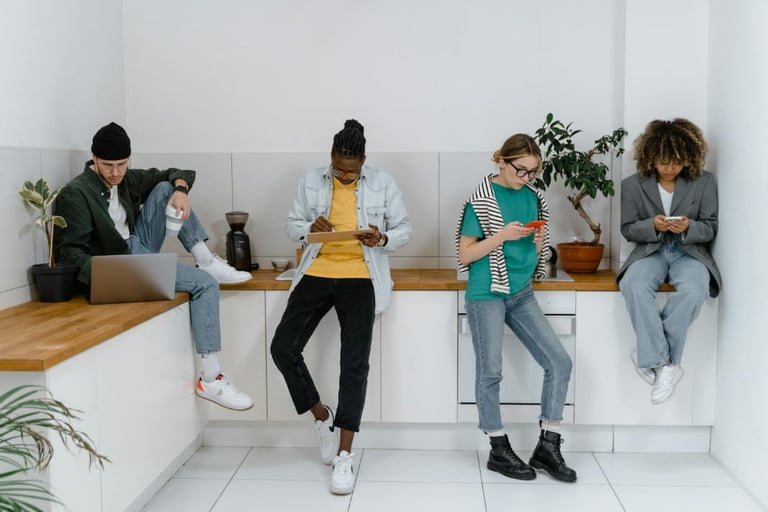 Young adults using digital devices showing the impact of mass media on social interaction.