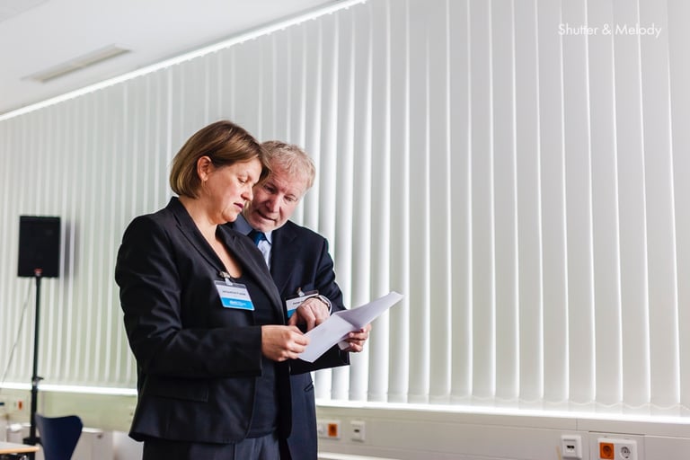 Die Organisatoren der Cbmi-Konferenz besprechen die Unterlagen.