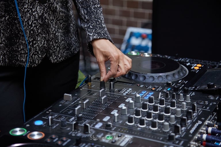 Ein weiblicher DJ nimmt Einstellungen vor.