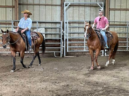 two horseback riders in an arena