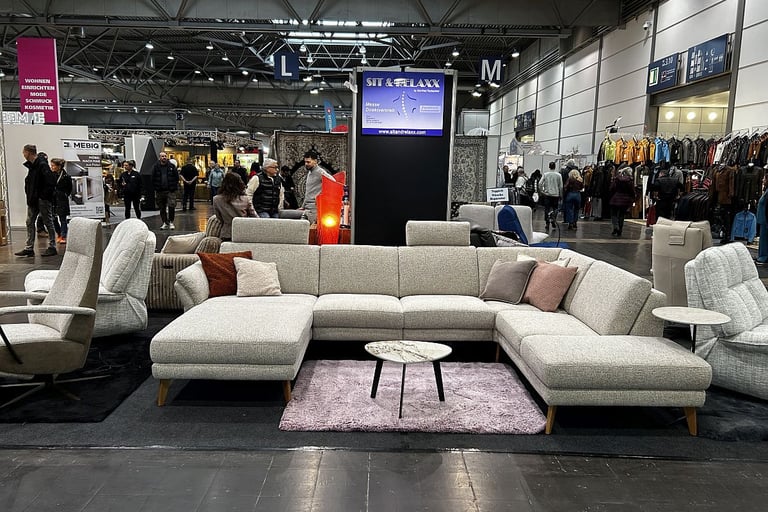 Modern grey sectional sofa and marble coffee table at a furniture trade show exhibition.