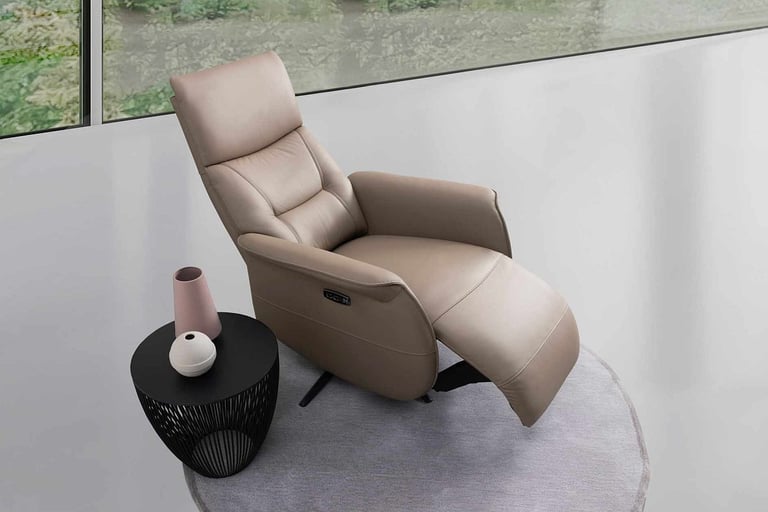 a reclining chair with a vase of flowers