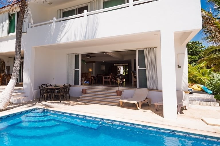 Beautiful exterior view of the retreat villa in Akumal, Mexico, surrounded by lush greenery, perfect for yoga retreats and me