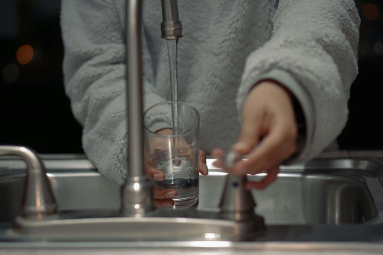 Woman turns on the kitchen sink