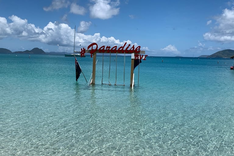 a beach scene and sign that says BVI and Paradise in the British Virgin Islands 