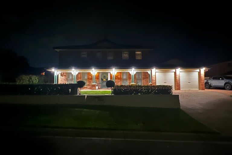 a house lit up outside by downlights 