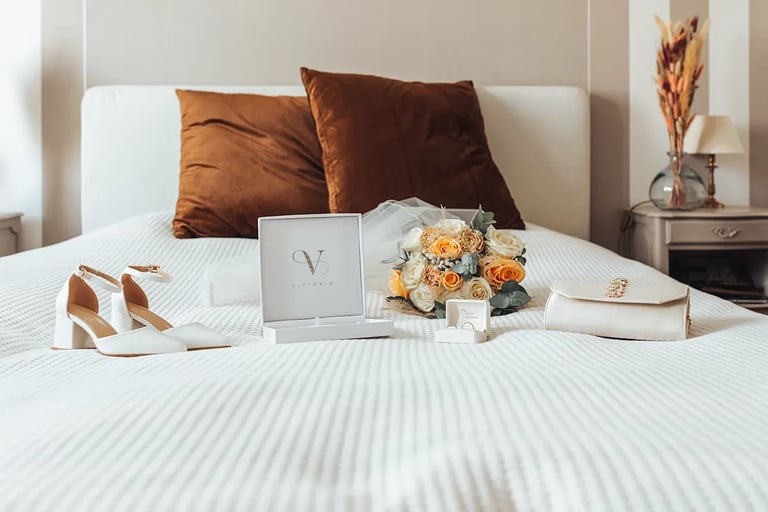 Accessoires de la mariée disposés de façon élégante sur un lit pendant les préparatifs.