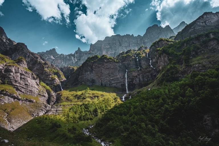 a waterfall in the mountains with a waterfall in the background