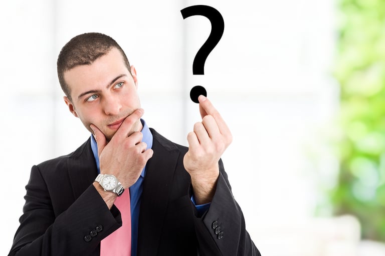 a man in a suit and tie is holding a question mark
