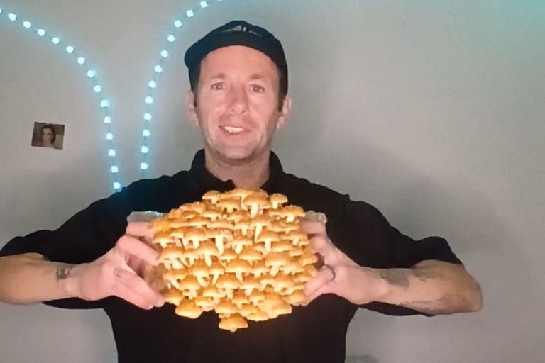 Mark from Inland Mushrooms holding a large homegrown chestnut mushroom cluster