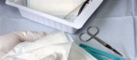 a person in a gloved gloved hand holding a pair of scissors and a