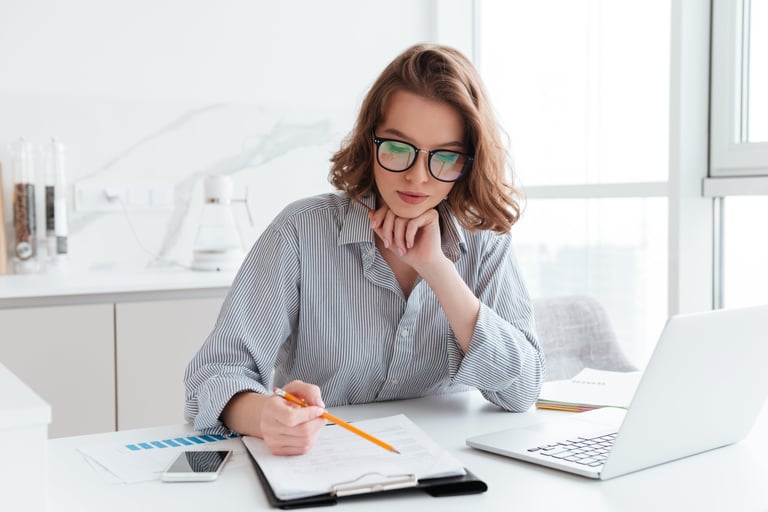 a woman sitting at a desk with a notebook and a notebook