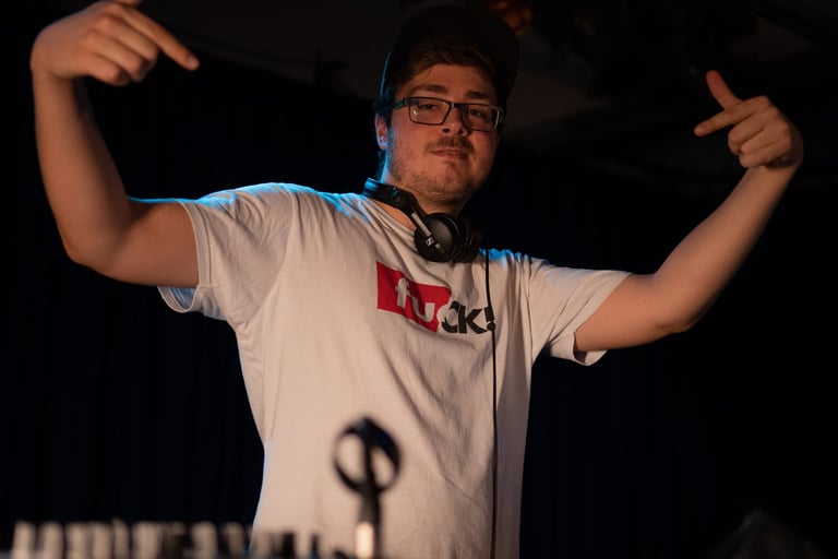 a man in a white shirt and headphones on a dj - board