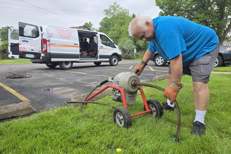 John cabling a sewer in front of his plumbing truck.