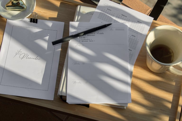 a notebook, pen and tea sit on a wooden platter