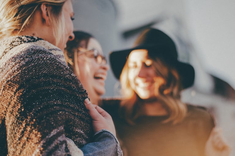three women chat at a gathering
