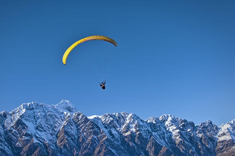 a person parasailing over a mountain