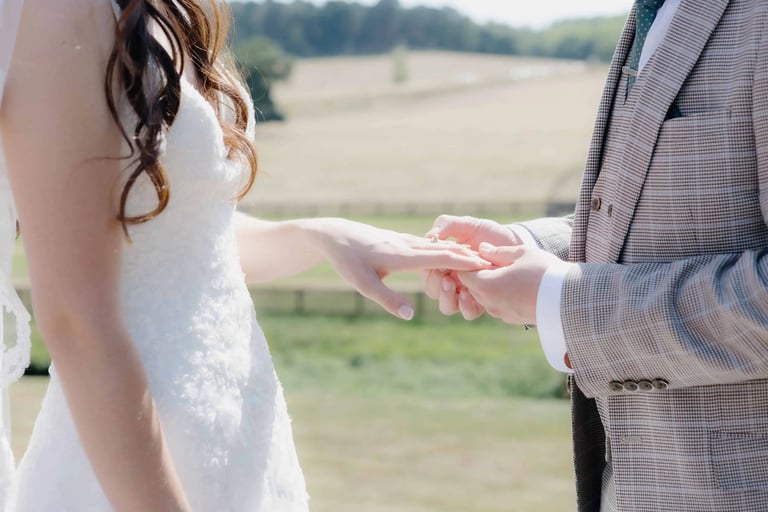 Groom placing a ring onto the finger of the bride