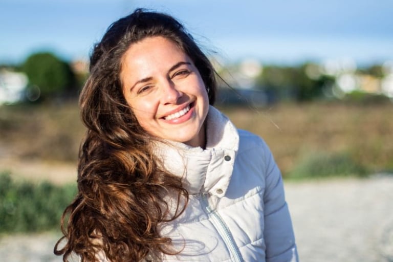 a woman with long hair and a white jacket